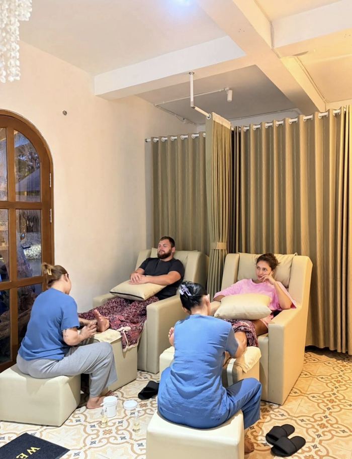Two guests relaxing in reclining chairs during a foot treatment
