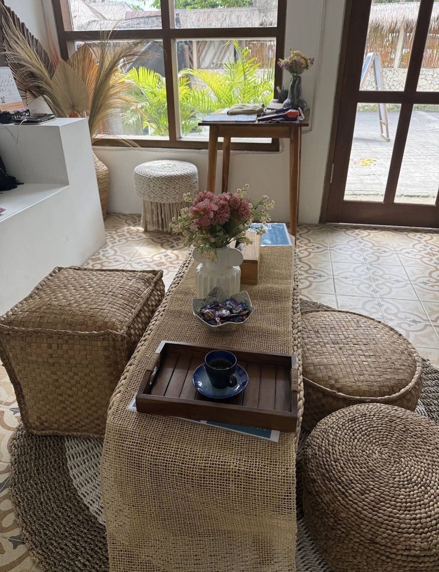 Reception area at Chellvan Spa with woven poufs, fresh flowers and a garden view